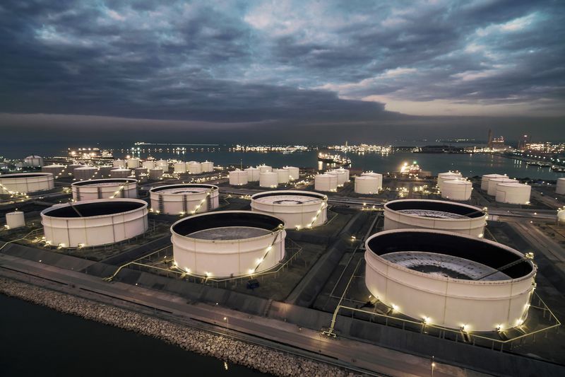 Oil storage tank in oil refinery near the sea at night, Rayong, Thailand.