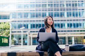Woman working with laptop outdoors