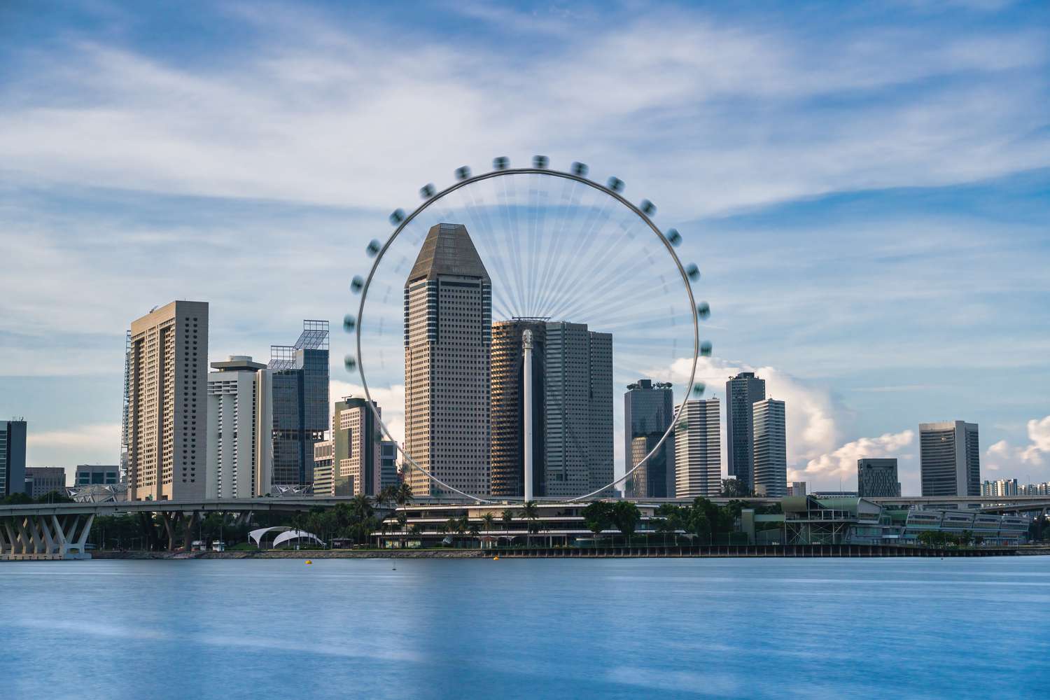 Singapore Flyer with skyscrapers in the background, with a ferris wheel in the city.