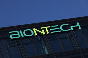 The green BioNTech logo is seen on the side of a black office building.