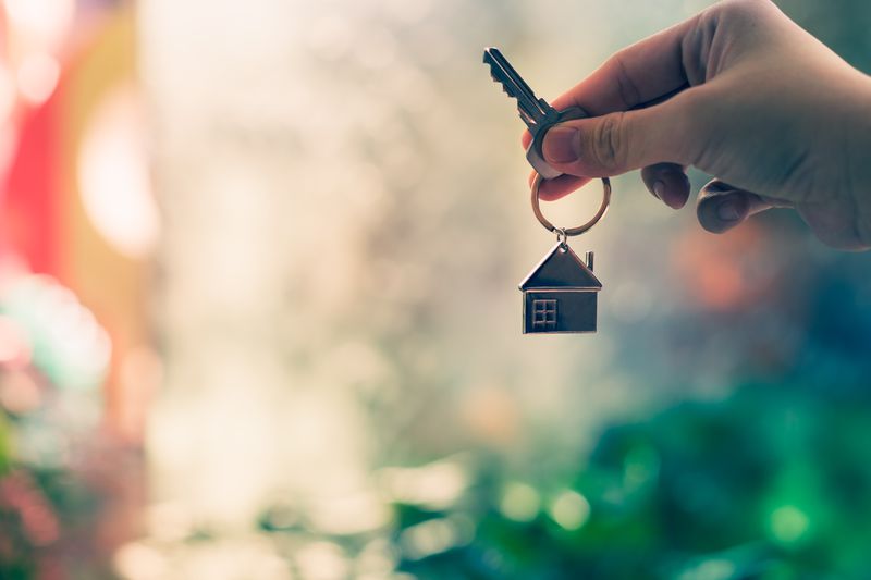 House model and key in hand of home insurance broker, agent or salesperson. Real estate agent offer house, property insurance and security, affordable housing concepts