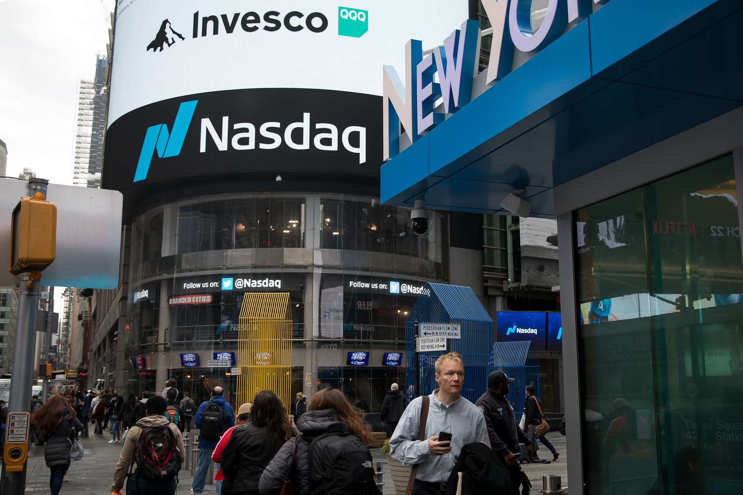 Pedestrians pass in front of the Nasdaq MarketSite in the Times Square neighborhood of New York, U.S