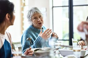 A woman is talking to others at a table.