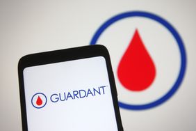 Guardant Health logo is seen on a smartphone and a PC screen