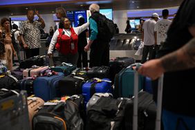 A Delta employee assists customers looking for bags in the Delta Air Lines baggage claim area Los Angeles International Airport (LAX) on July 24, 2024
