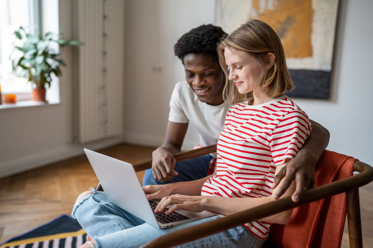 Young couple looking at laptop together in their home. 