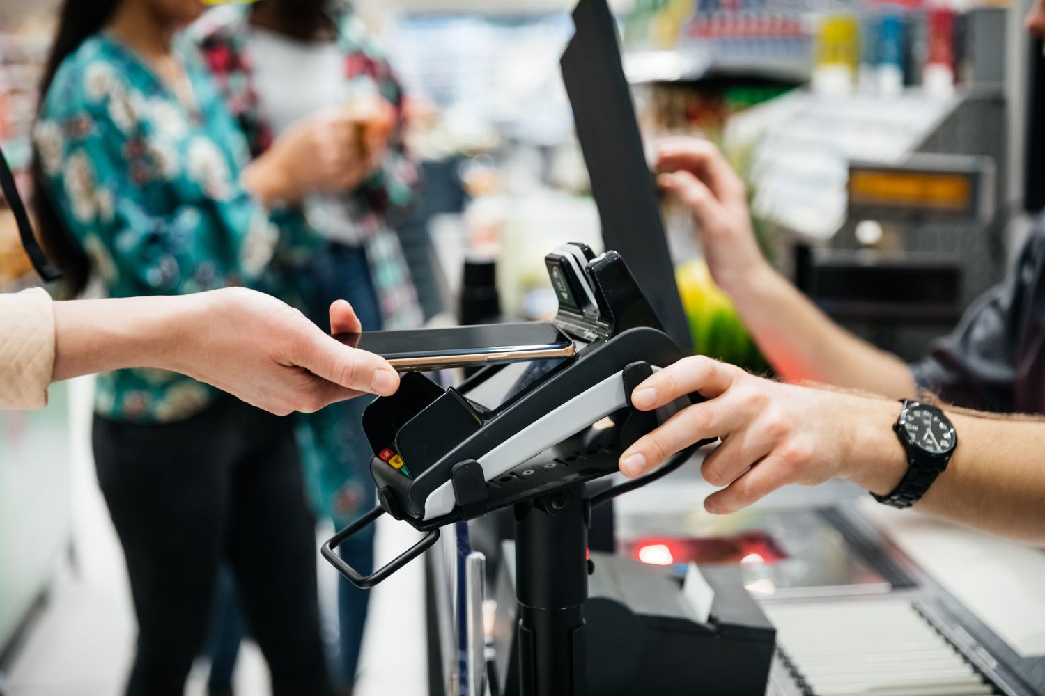 Consumers wait in line at a checkout counter in a store after the U.S. Federal Reserve boosted consumer spending through the TALF program.