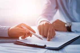 Human hands working with documents at desk and signing contract.