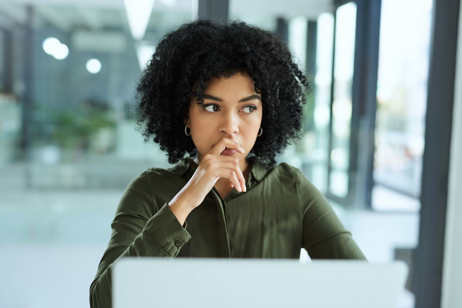 A thoughtful woman at a computer 