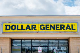 The yellow and black Dollar General sign is seen above the entrance to a store.
