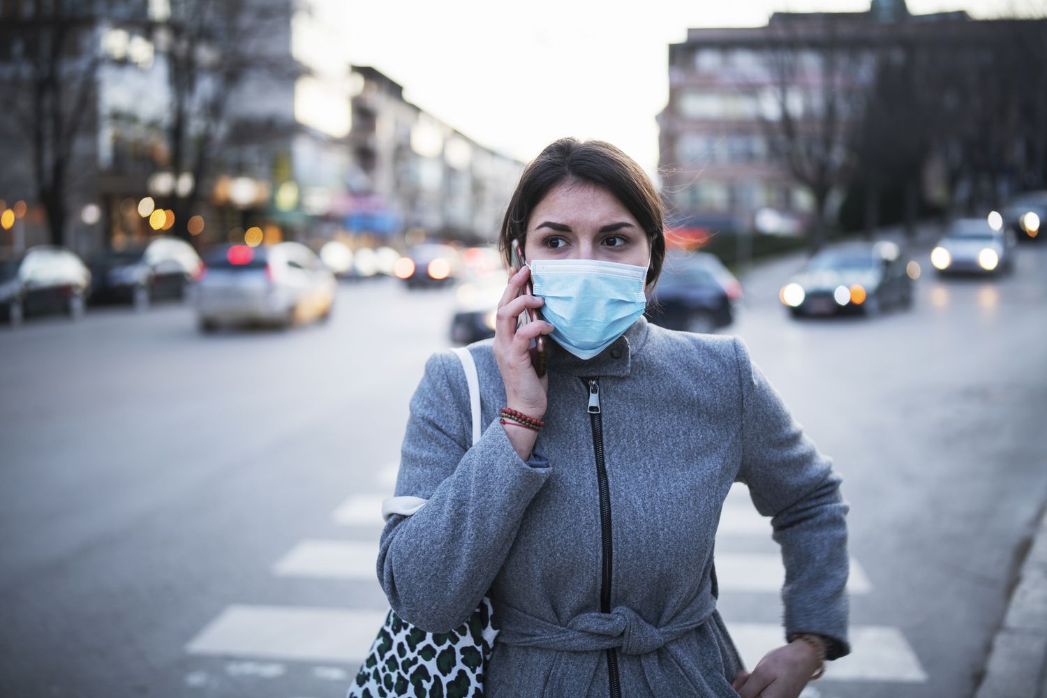 Woman wearing mask and talking on a cell phone