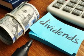 Dividends Concept. Stack of Dollars and Calculator