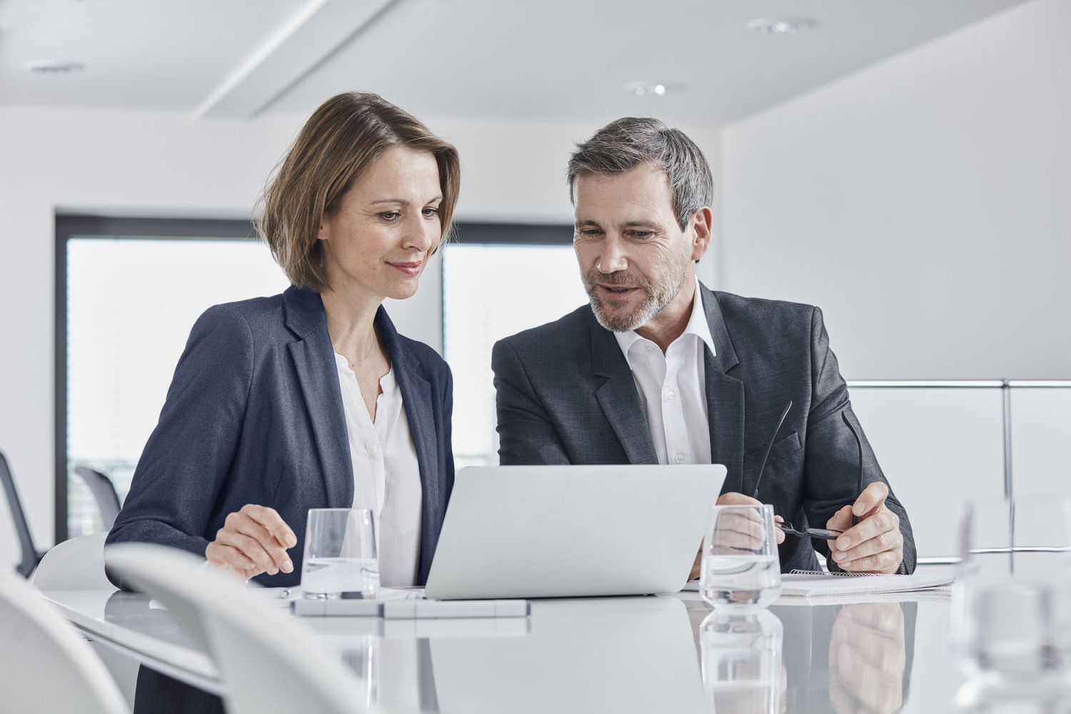 Colleagues in an office looking at a laptop