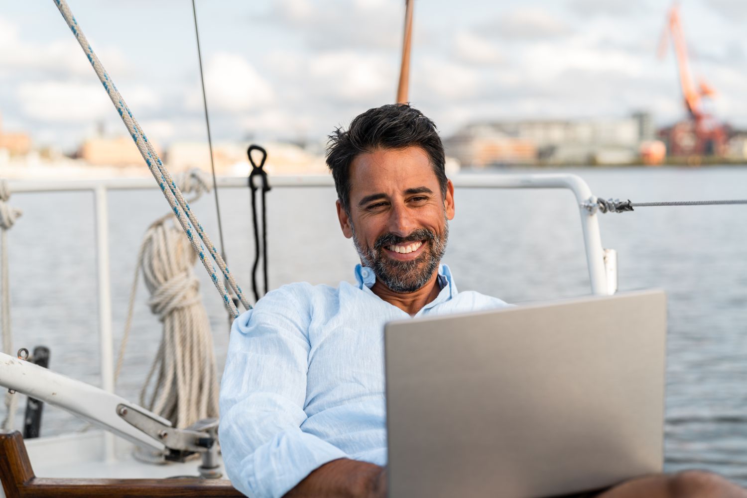 Person with a laptop in a sailboat.