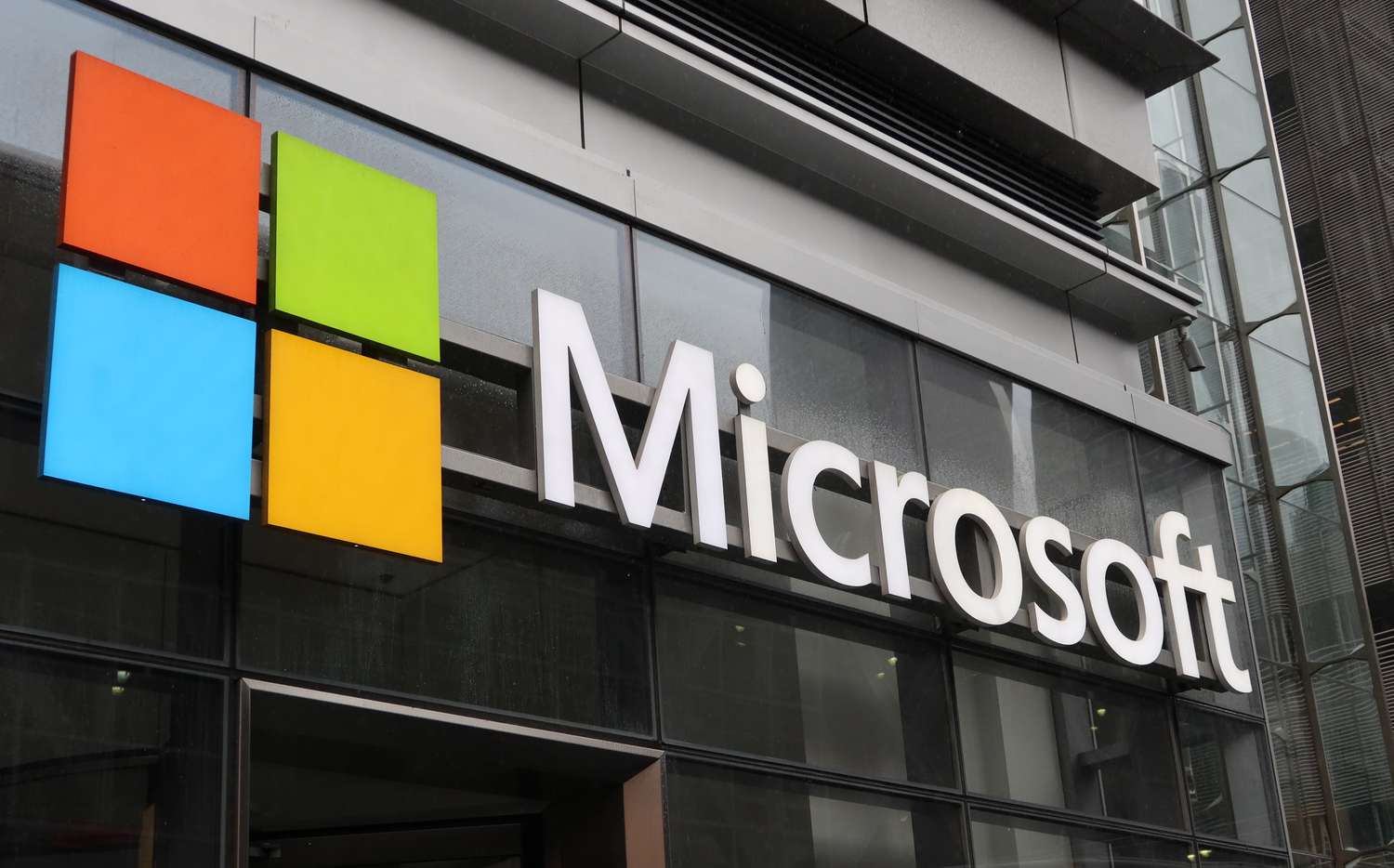Microsoft corporate logo hangs on the side of their office building