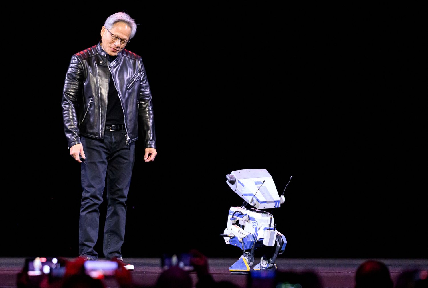 Nvidia CEO Jensen Huang talks to a robot during a keynote session at the company's GTC AI conference, in San Jose, California on March 18, 2025.