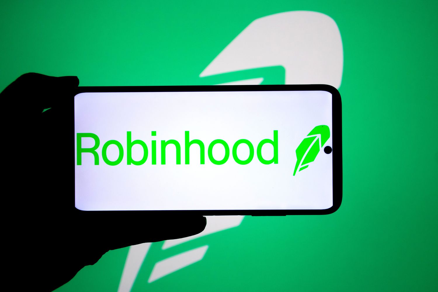 A Robinhood logo seen displayed on a smartphone and in the background
