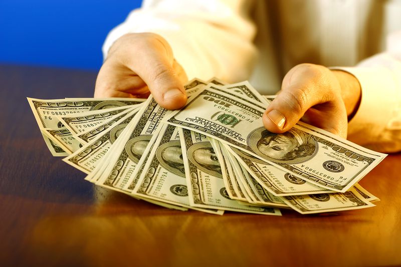 Man Holding Handful of Us $100 Bills