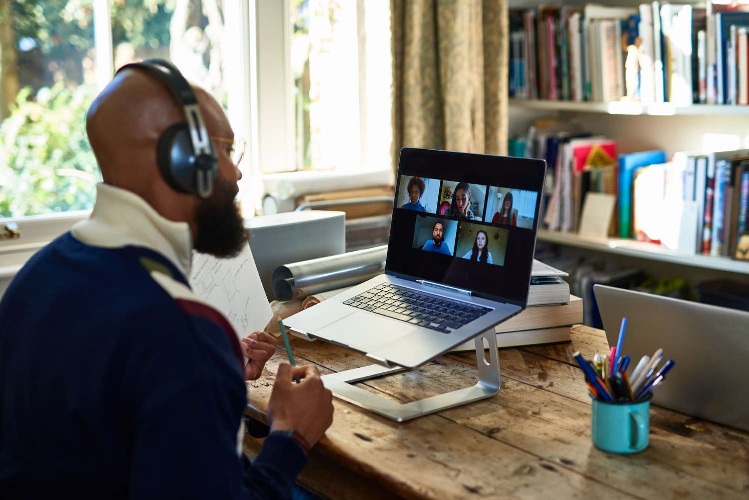 A man making a video conference call on laptop in home office 