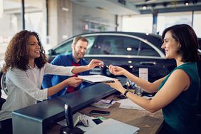 Couple buying new car and signing contract