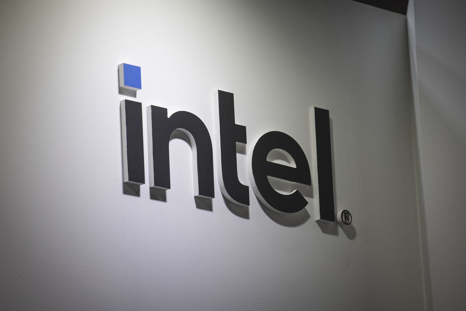 The black and blue Intel logo is seen on a white wall.