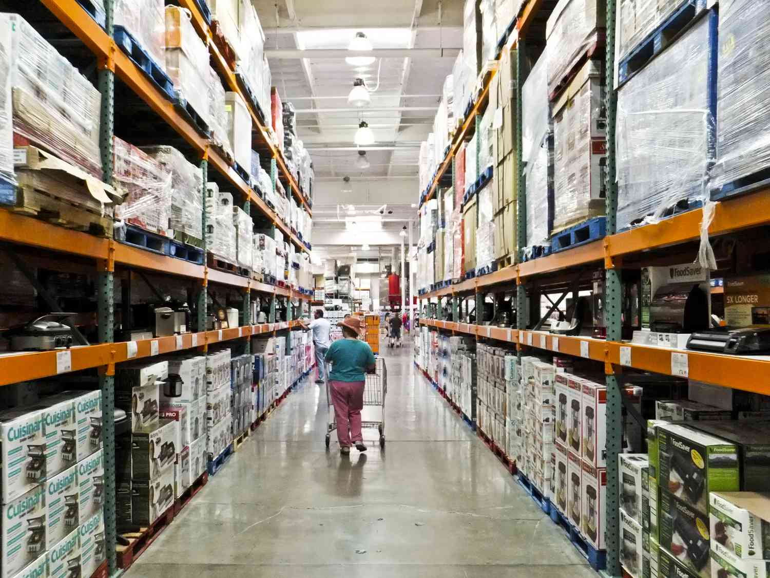 A shopper walks down a Costco aisle. 