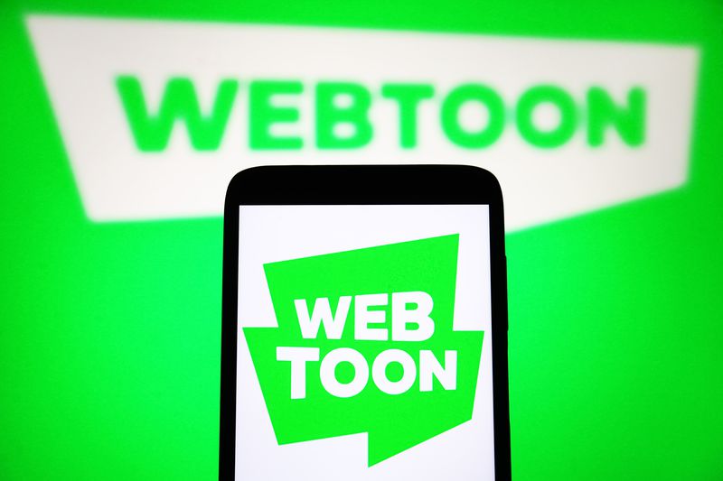 A Webtoon Entertainment Inc. logo is seen on a smartphone and on a PC screen