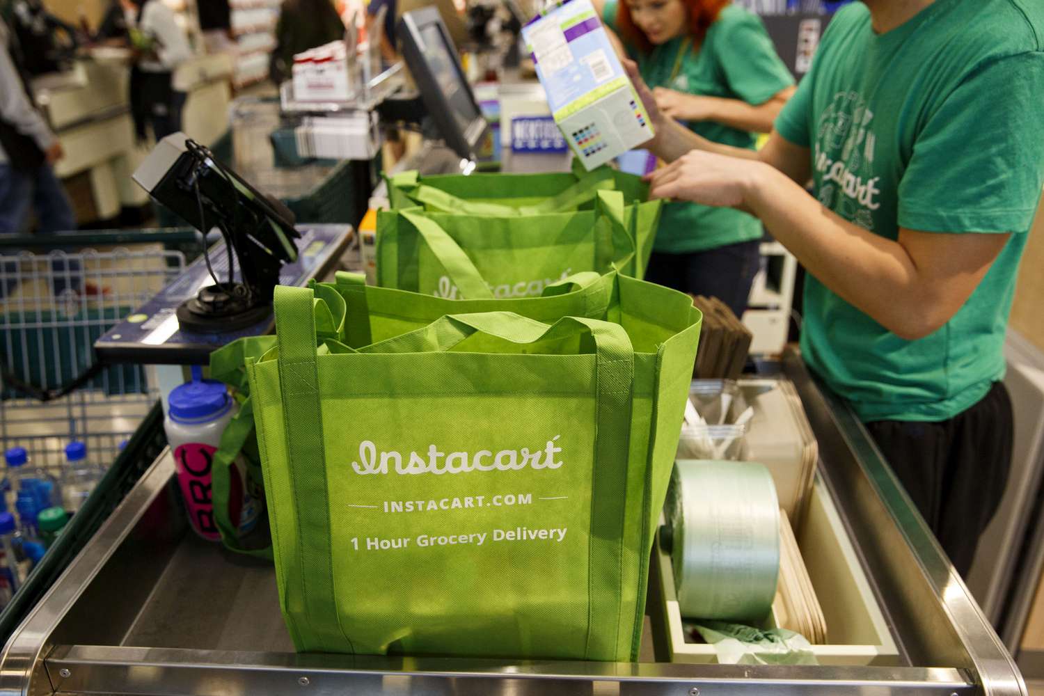InstaCart employees fulfill orders for delivery at the new Whole Foods Market 