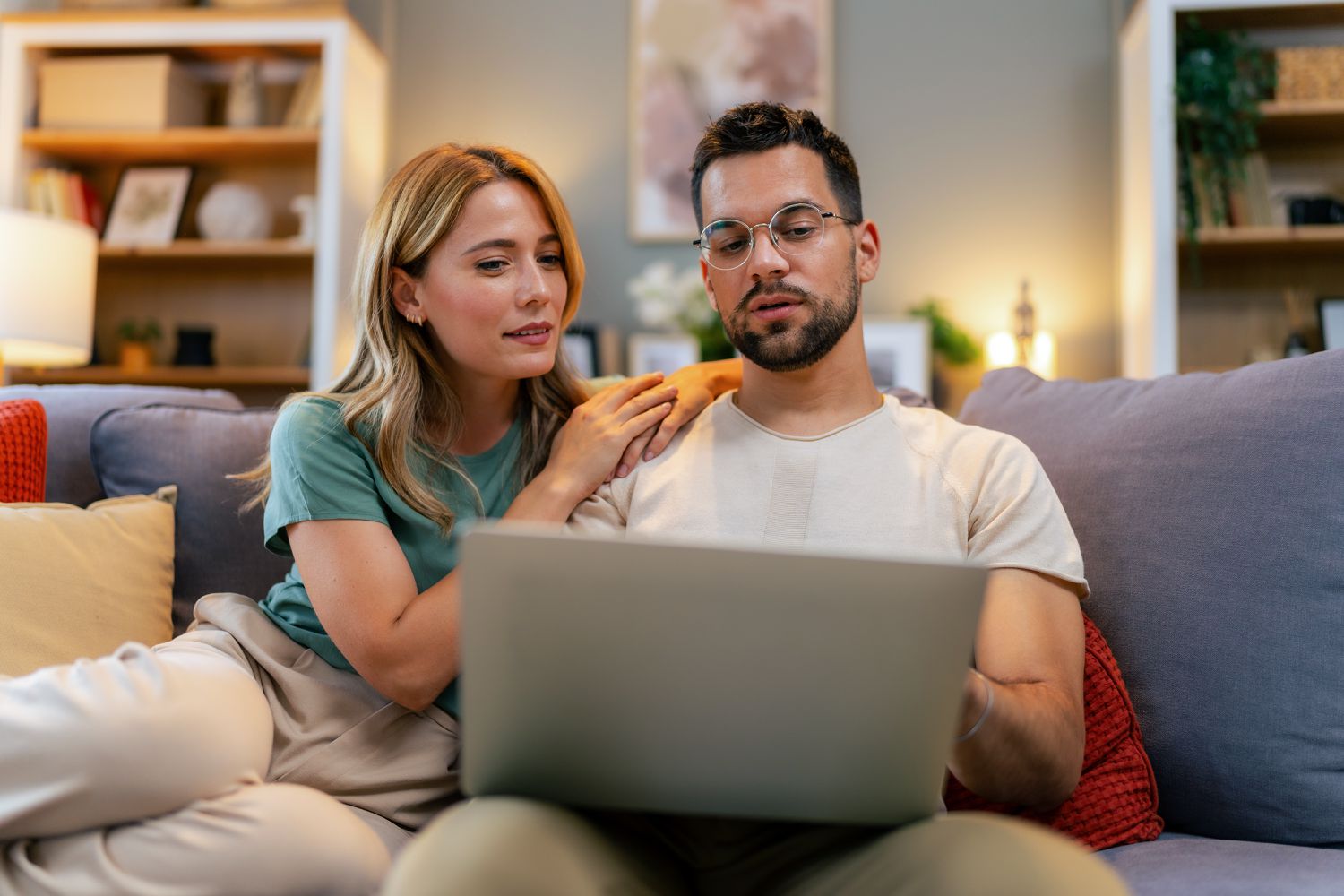 Young couple reviewing their finances while using their laptop
