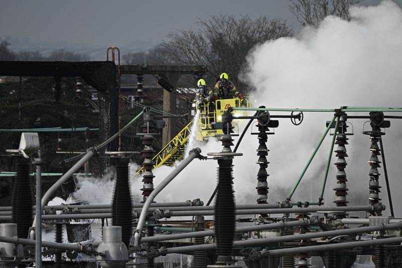 Members of the fire brigade attend the scene after a major fire at an electrical substation at Heathrow airport. 