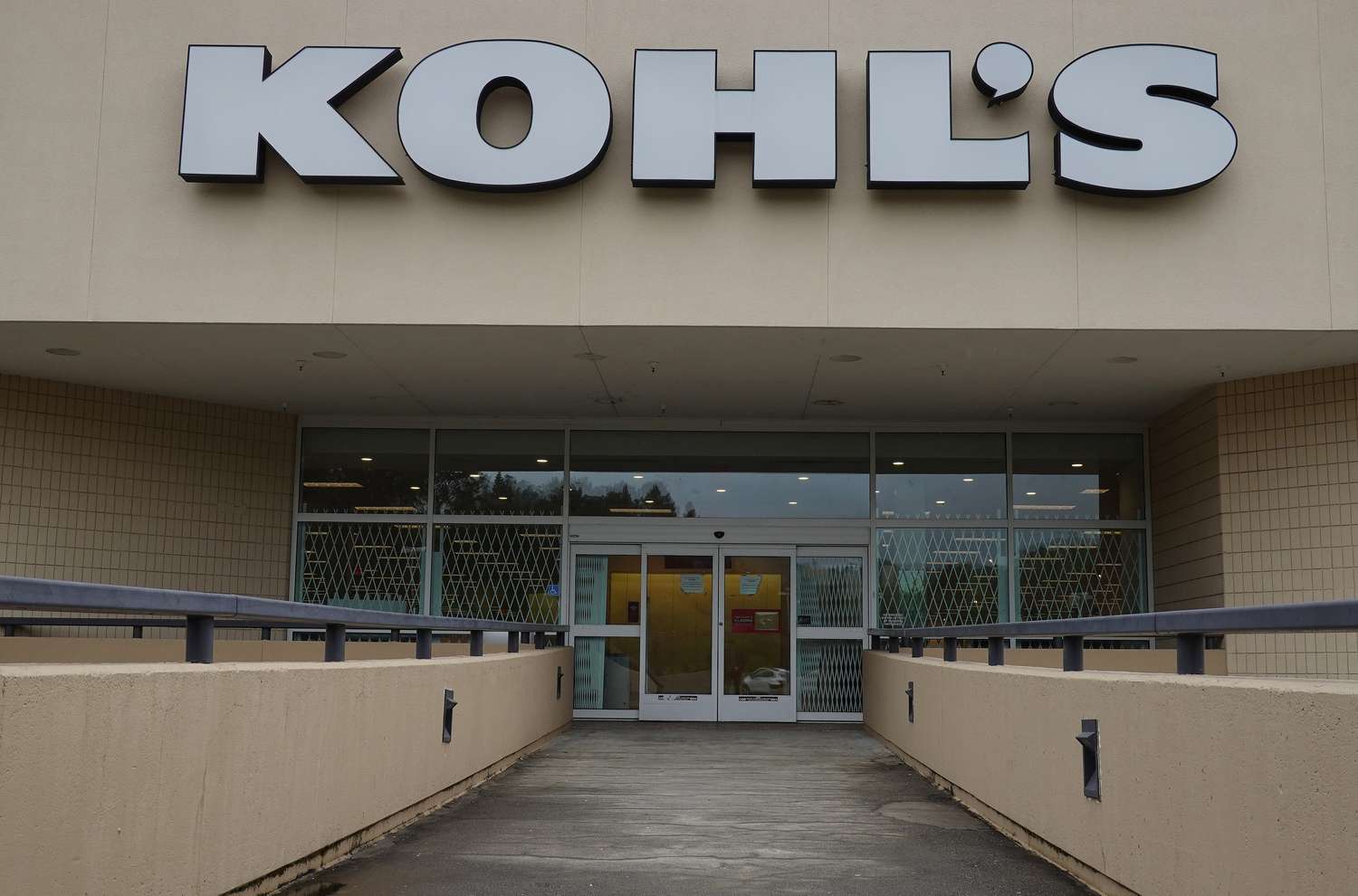The white Kohl's logo is seen above the entrance to a store.