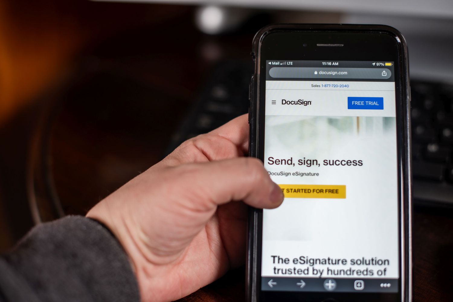 Hand holding a smartphone with Docusign app on the screen