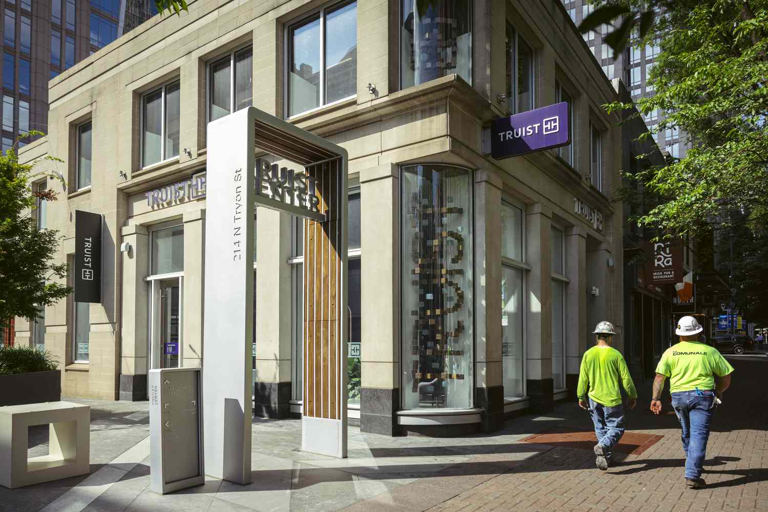 Construction workers walk past a Truist Financial bank branch at the company headquarters in Charlotte, North Carolina