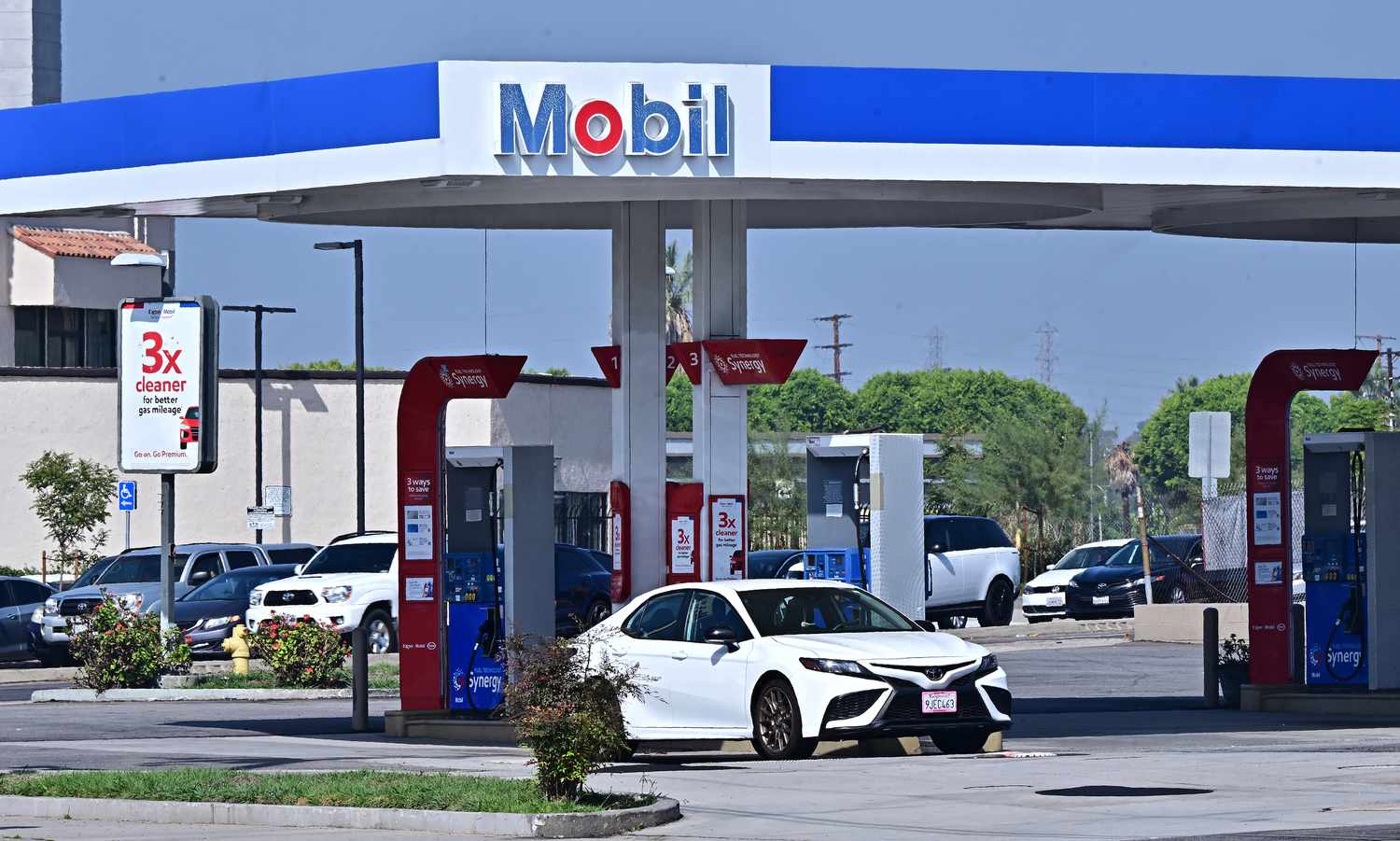 A white car is seen parked at a Mobil gas station.