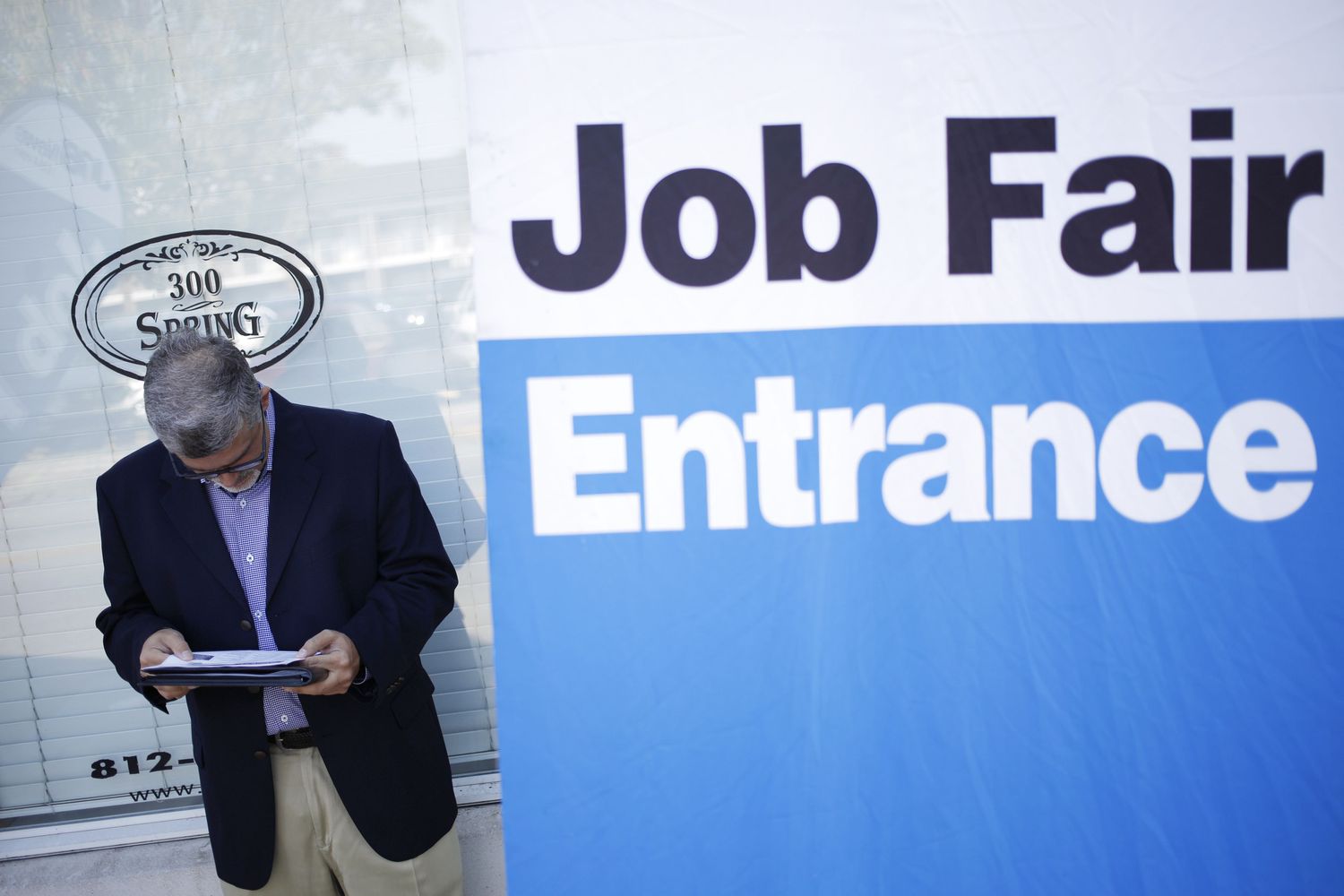 Person standing next to a sign for a job fair