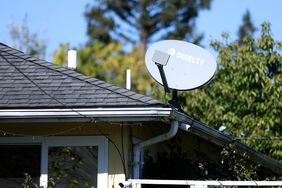 A DirecTV satellite dish is seen mounted to a building