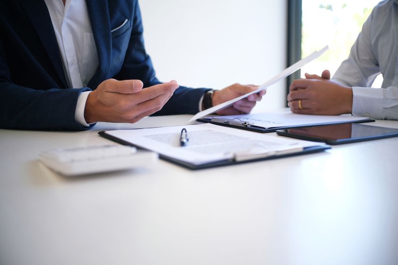 An insurance agent discussing with client at desk.