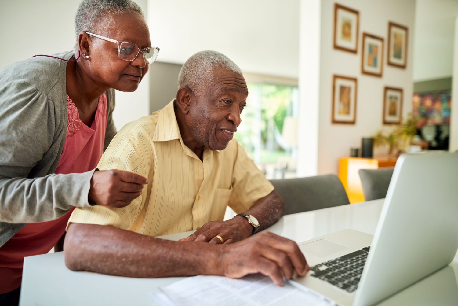 Senior couple reviews their Medigap options using laptop in the living room.