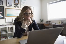 Businesswoman entrepreneur working at laptop in studio office.