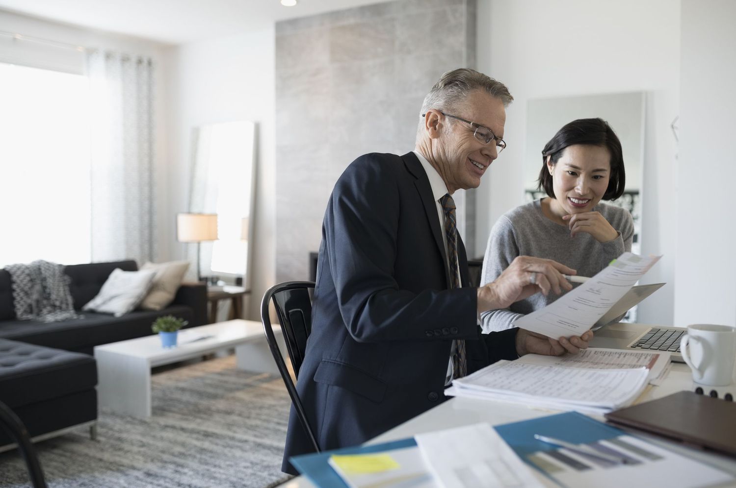 Financial advisor and woman with a laptop meeting in dining room
