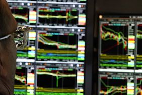 A trader looking screens with stock price charts at the New York Stock Exchange.