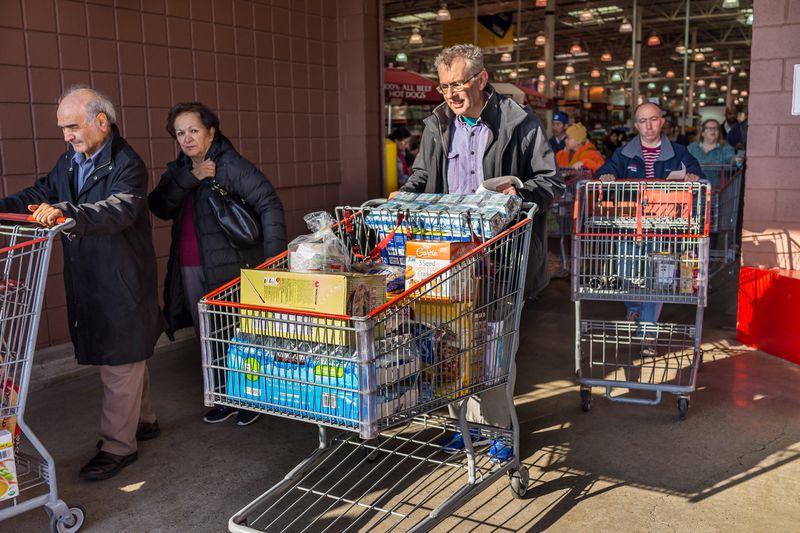 People with shopping carts filled with groceries walking out of Costco store in Virginia