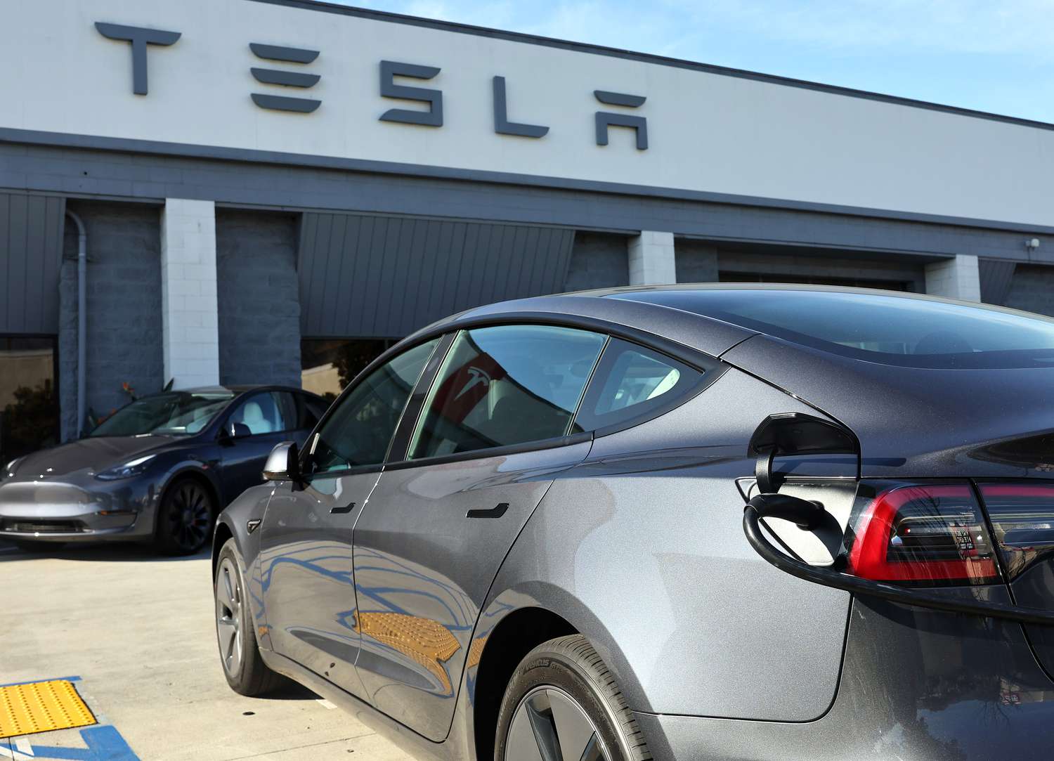 A Tesla car on the lot of a dealership.
