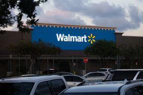 Cars are parked in a Walmart parking lot. 