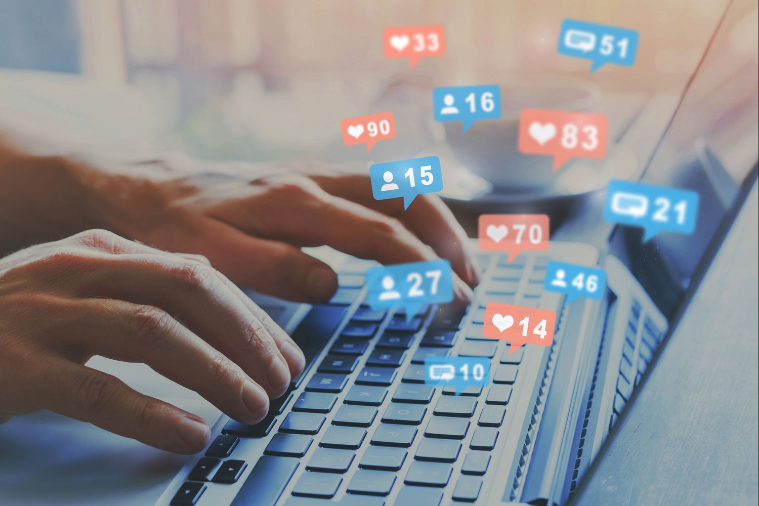 Person using a laptop keyboard while social media like and love icons float above the keys