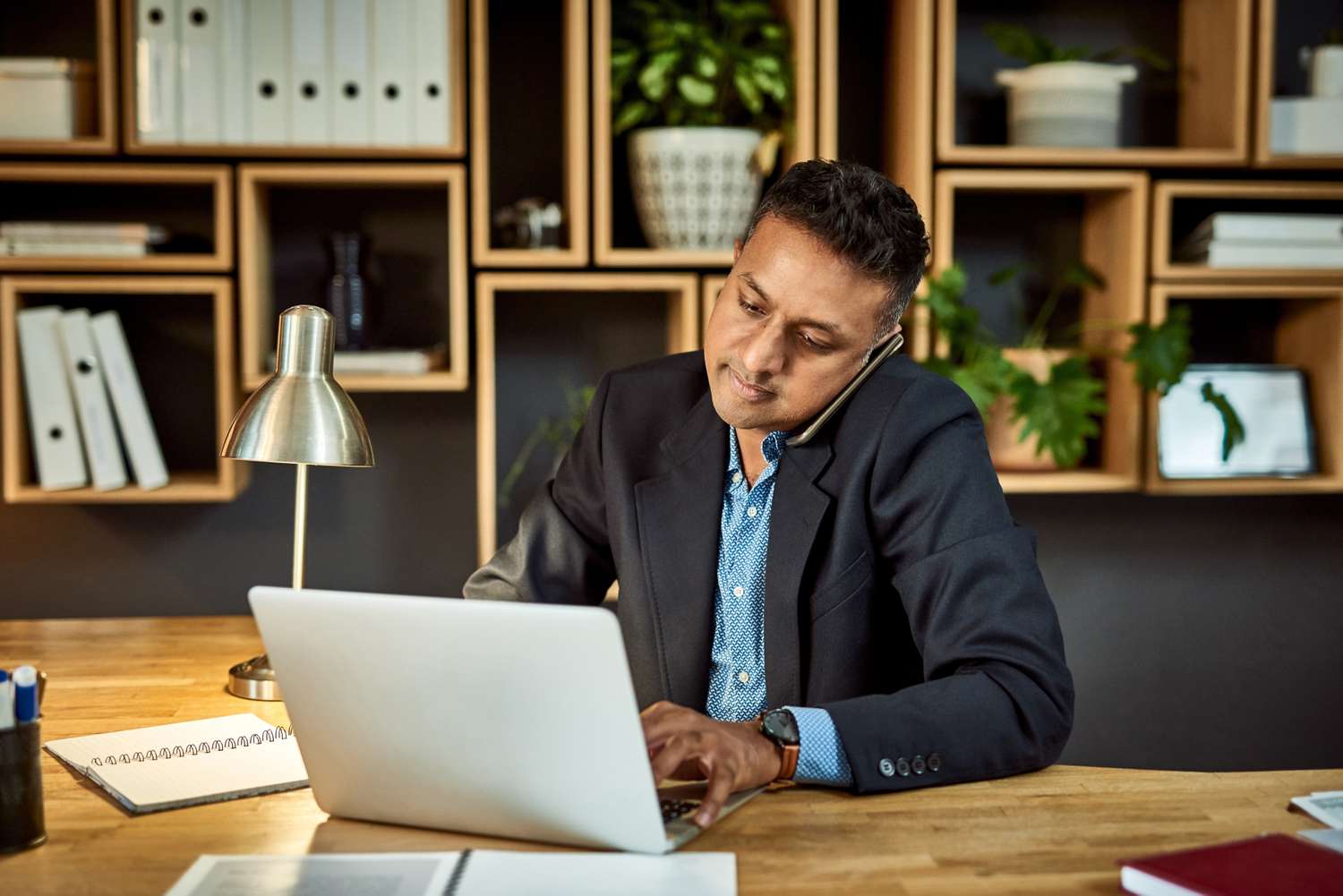 An investor uses their shoulder to hold a cellphone to their ear as they talk to a financial advisor about the soft call provision for a bond they are considering.