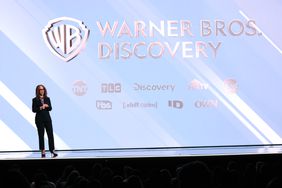 The Warner Bros. Discovery logo is seen on a screen, above the names of the TV channels the company owns.