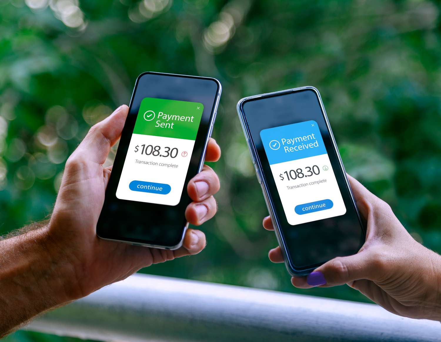 Two smartphones held by a woman and a man showing sending and receiving payments through a digital wallet application on a mobile phone. 