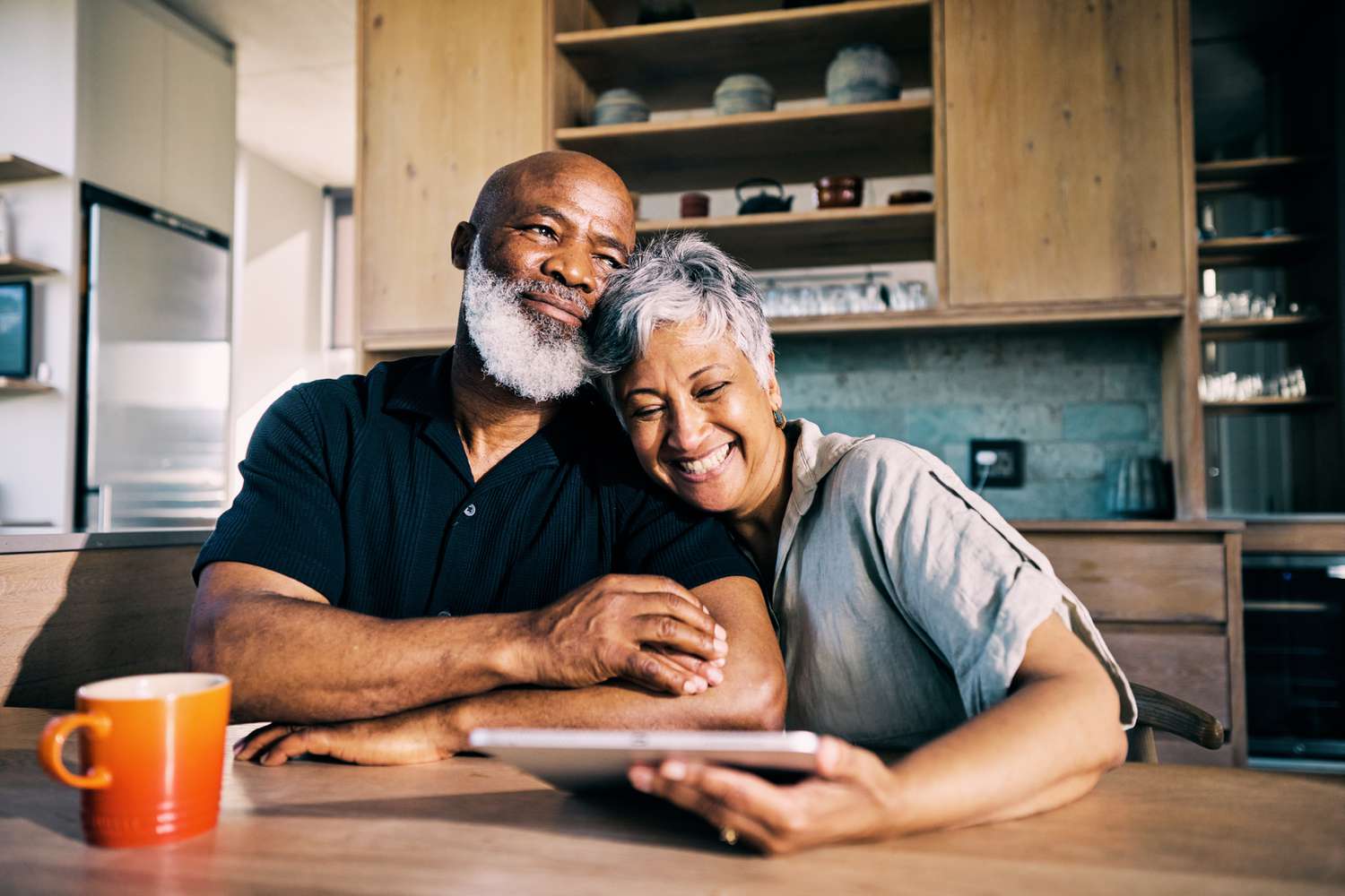 A retired couple celebrate at the kitchen table after reviewing the balance of their retirement annuity account.