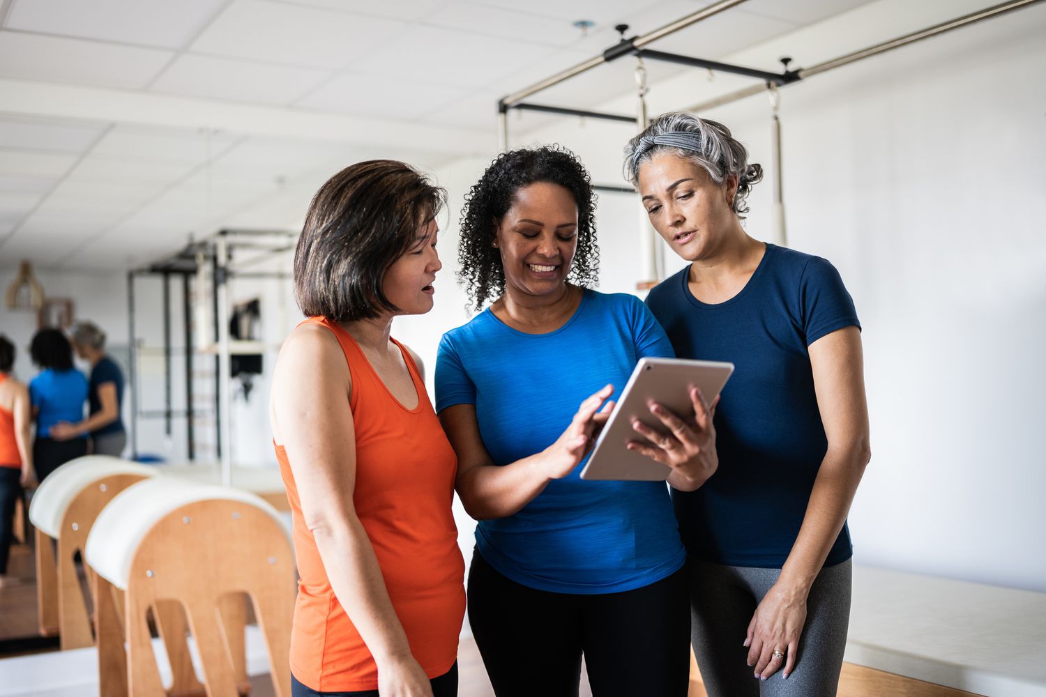 Mature women looking at a digital tablet at a pilates studio